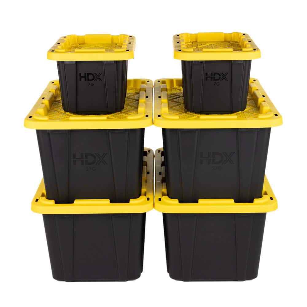 Stack of black and yellow moving totes in a garage